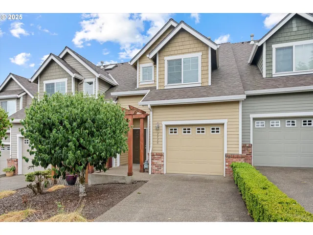 a view of a brick house with large windows and a yard