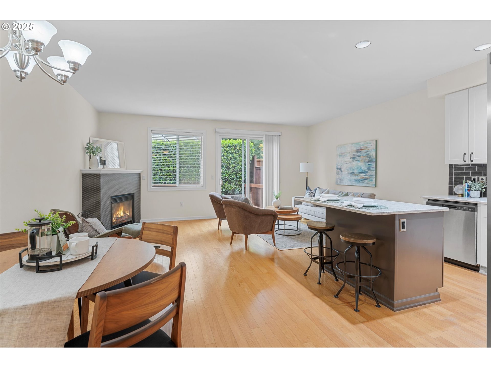 2926 Southwest Texas Street Portland, OR 97219 - Photo 3 of 16 a living room with furniture a fireplace and a dining table with kitchen view