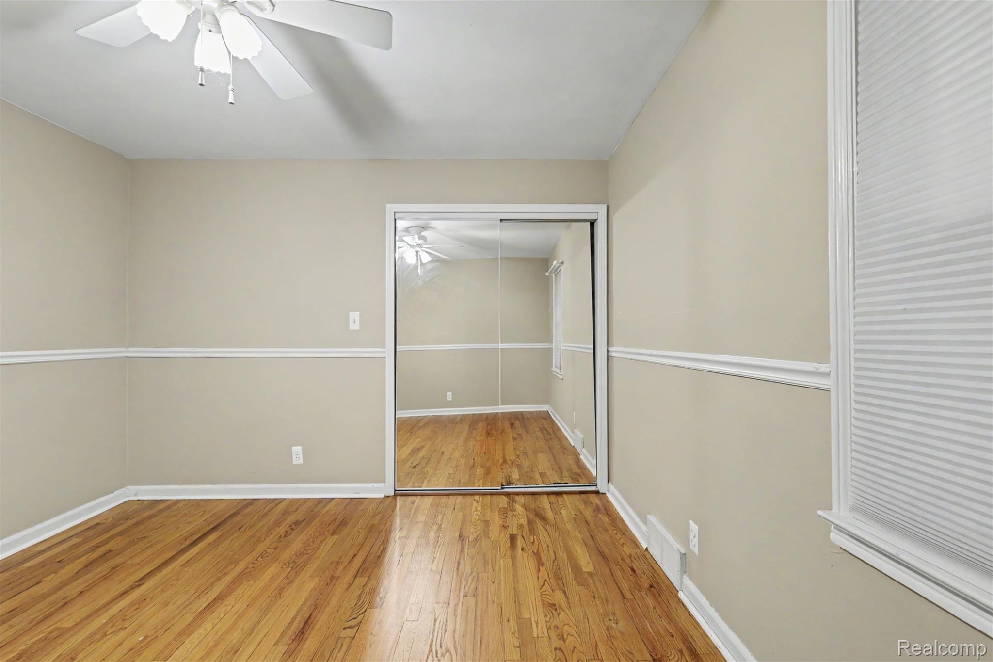 7136 Rosedale Boulevard Allen Park, MI 48101 - Photo 23 of 51 Hardwood flooring, mirrored closet doors, ceiling fan with integrated lighting, chair rail molding, and a window with cellular blinds