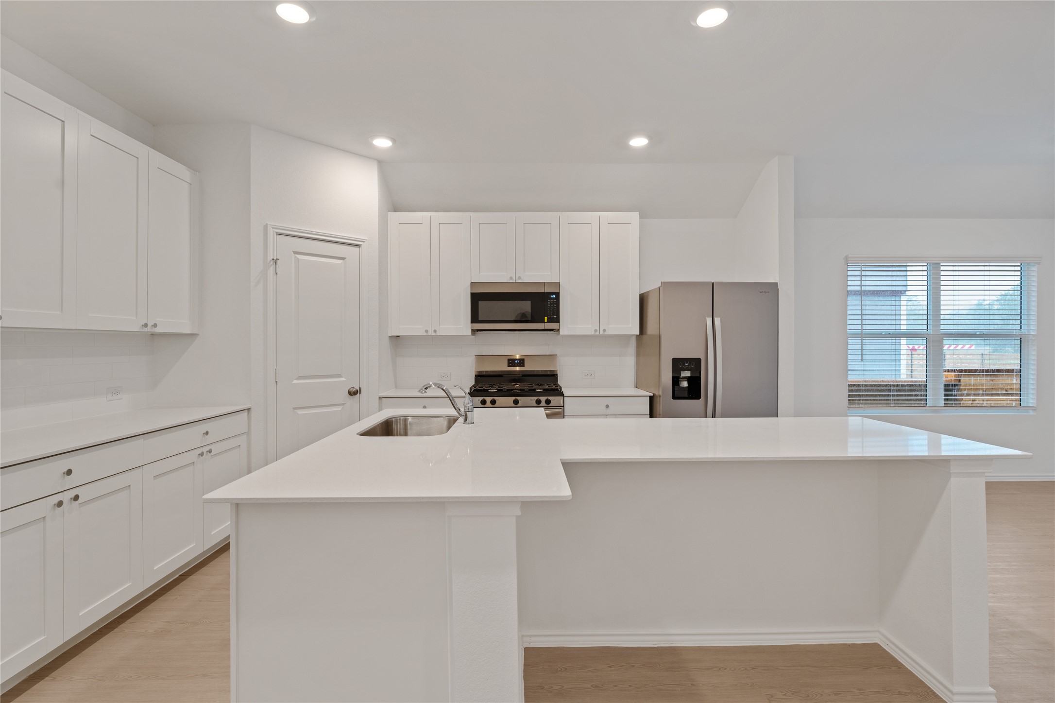 115 Parsons Kyle, TX 78640 - Photo 3 of 18 White cabinetry, solid surface counters, and stainless steel appliances complete this well-lit kitchen.