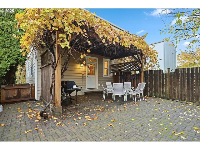a view of a patio with table and chairs with wooden fence and plants
