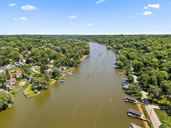 an aerial view of residential houses with outdoor space and lake view
