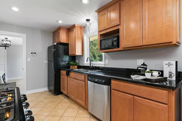 a kitchen with stainless steel appliances granite countertop a refrigerator stove and microwave