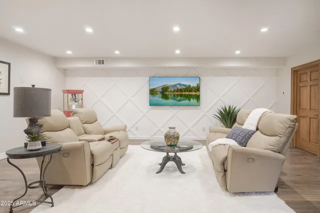 a bedroom with a bed a chandelier and dresser
