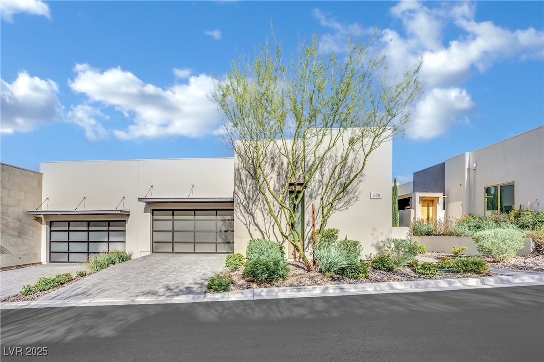 658 Falcon Summit Court Henderson, NV 89012 - Photo 1 of 99 Modern home with stucco siding, decorative driveway, and an attached garage