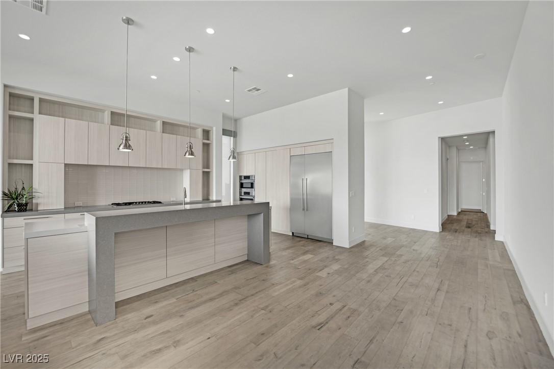 658 Falcon Summit Court Henderson, NV 89012 - Photo 10 of 99 Kitchen with an island with sink, modern cabinets, light brown cabinetry, and recessed lighting