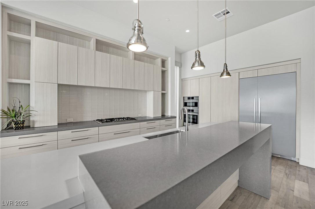658 Falcon Summit Court Henderson, NV 89012 - Photo 12 of 99 Kitchen with modern cabinets, open shelves, pendant lighting, appliances with stainless steel finishes, and dark stone countertops