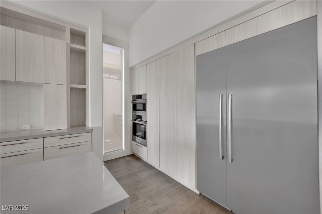 658 Falcon Summit Court Henderson, NV 89012 - Photo 13 of 99 Kitchen featuring appliances with stainless steel finishes, modern cabinets, open shelves, light wood finished floors, and light brown cabinetry