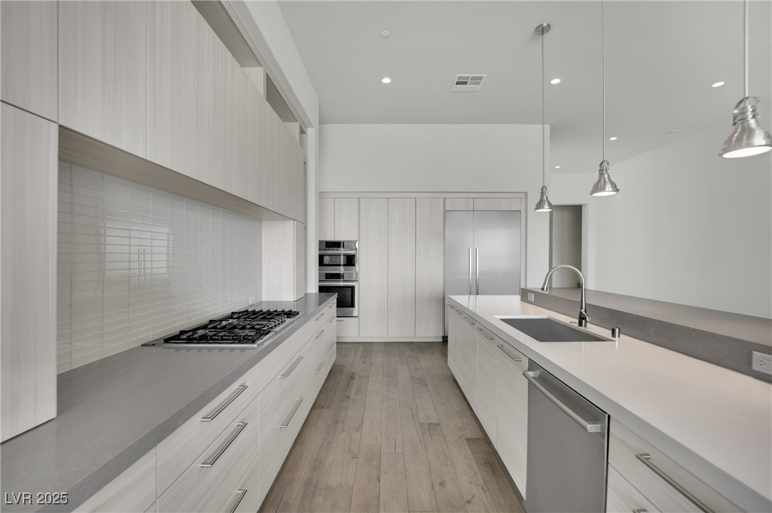 658 Falcon Summit Court Henderson, NV 89012 - Photo 15 of 99 Kitchen with modern cabinets, stainless steel appliances, light wood-style flooring, and recessed lighting