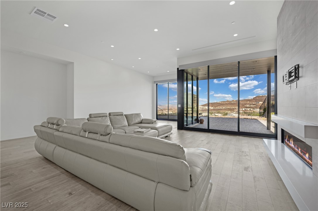 658 Falcon Summit Court Henderson, NV 89012 - Photo 18 of 99 Living area with light wood-type flooring, a large fireplace, recessed lighting, and floor to ceiling windows