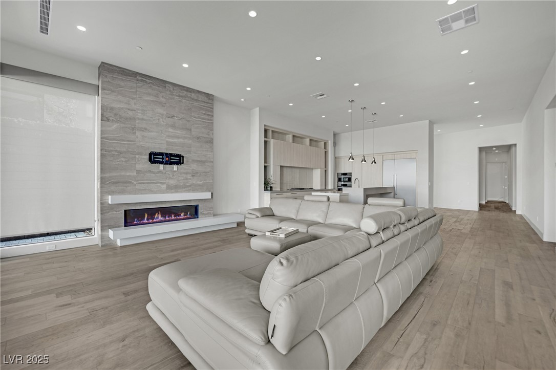658 Falcon Summit Court Henderson, NV 89012 - Photo 22 of 99 Living area with light wood-style floors, recessed lighting, and a tile fireplace