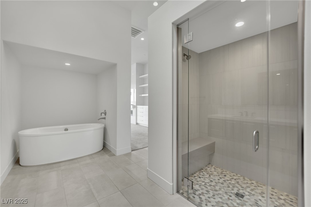 658 Falcon Summit Court Henderson, NV 89012 - Photo 34 of 99 Full bathroom featuring recessed lighting, a stall shower, a freestanding bath, and light tile patterned floors