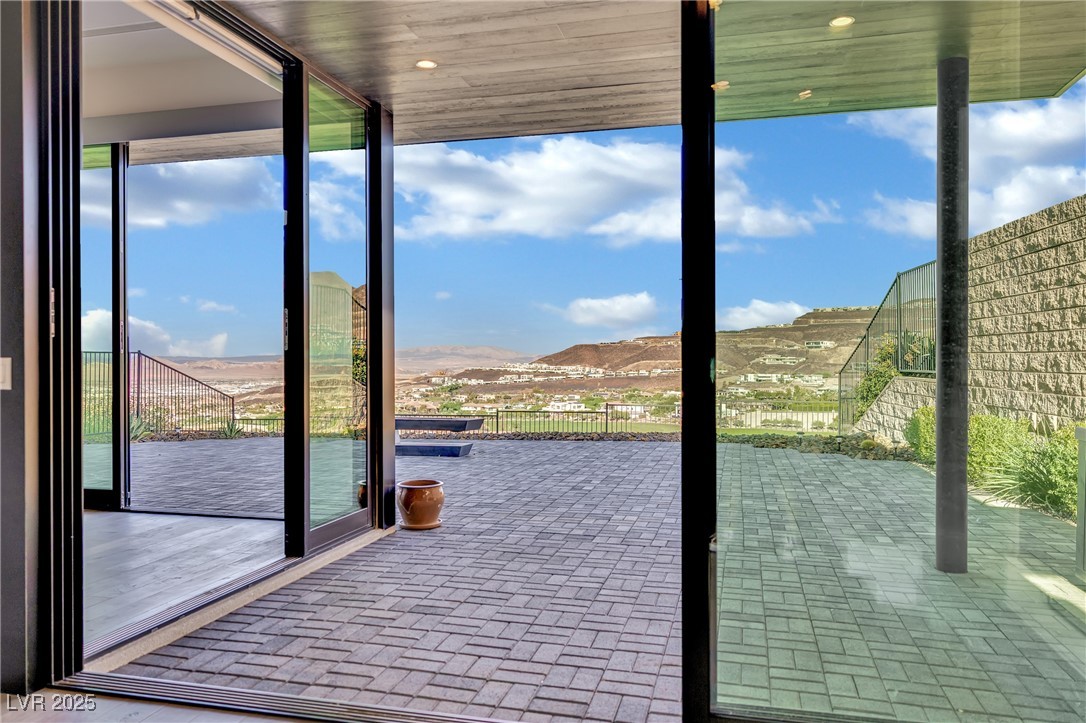 658 Falcon Summit Court Henderson, NV 89012 - Photo 59 of 99 Doorway with brick floors, a mountain view, plenty of natural light, and floor to ceiling windows