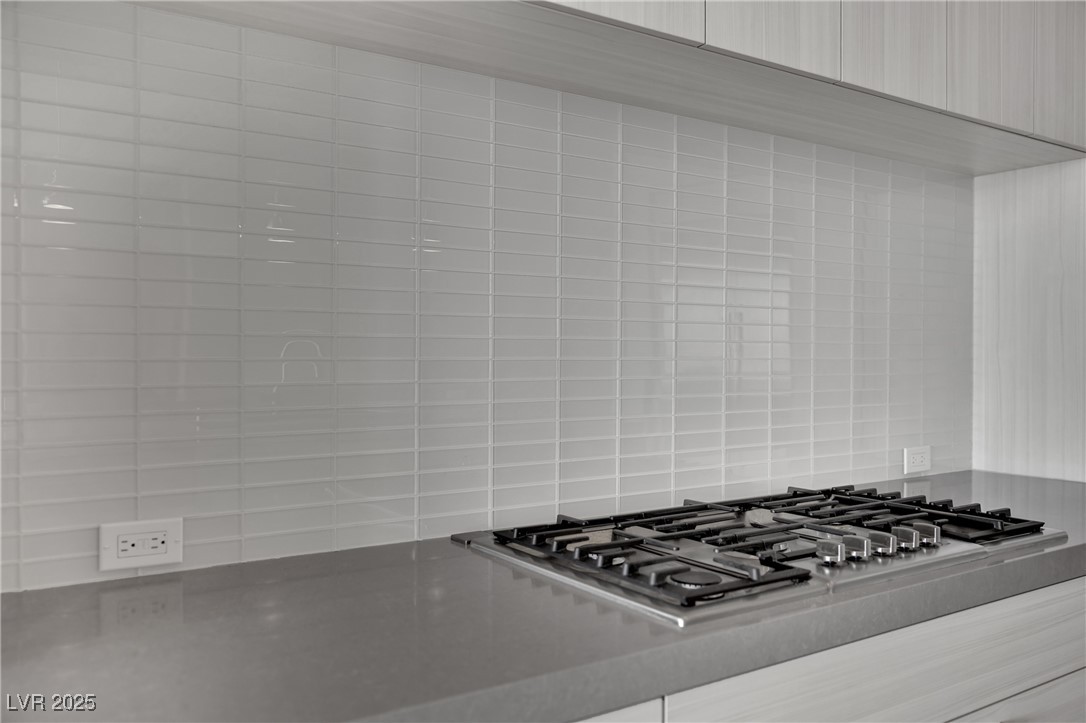 658 Falcon Summit Court Henderson, NV 89012 - Photo 61 of 99 Kitchen view of stainless steel gas cooktop, light stone countertops, and decorative backsplash