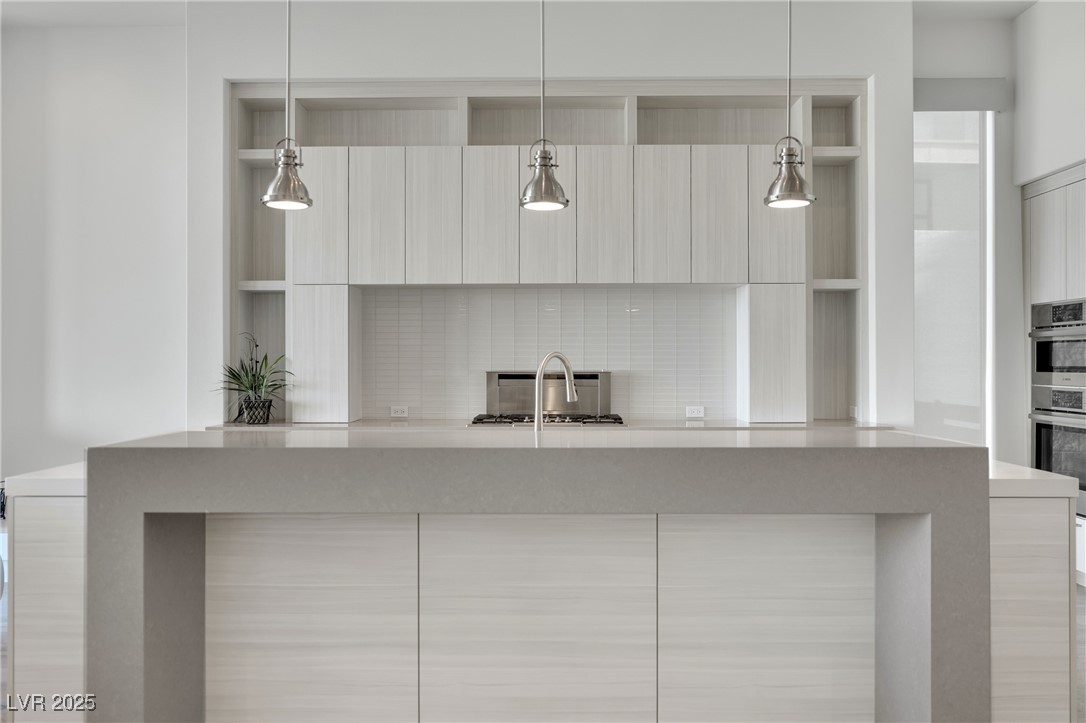 658 Falcon Summit Court Henderson, NV 89012 - Photo 65 of 99 Kitchen with light stone countertops, decorative light fixtures, modern cabinets, and double oven