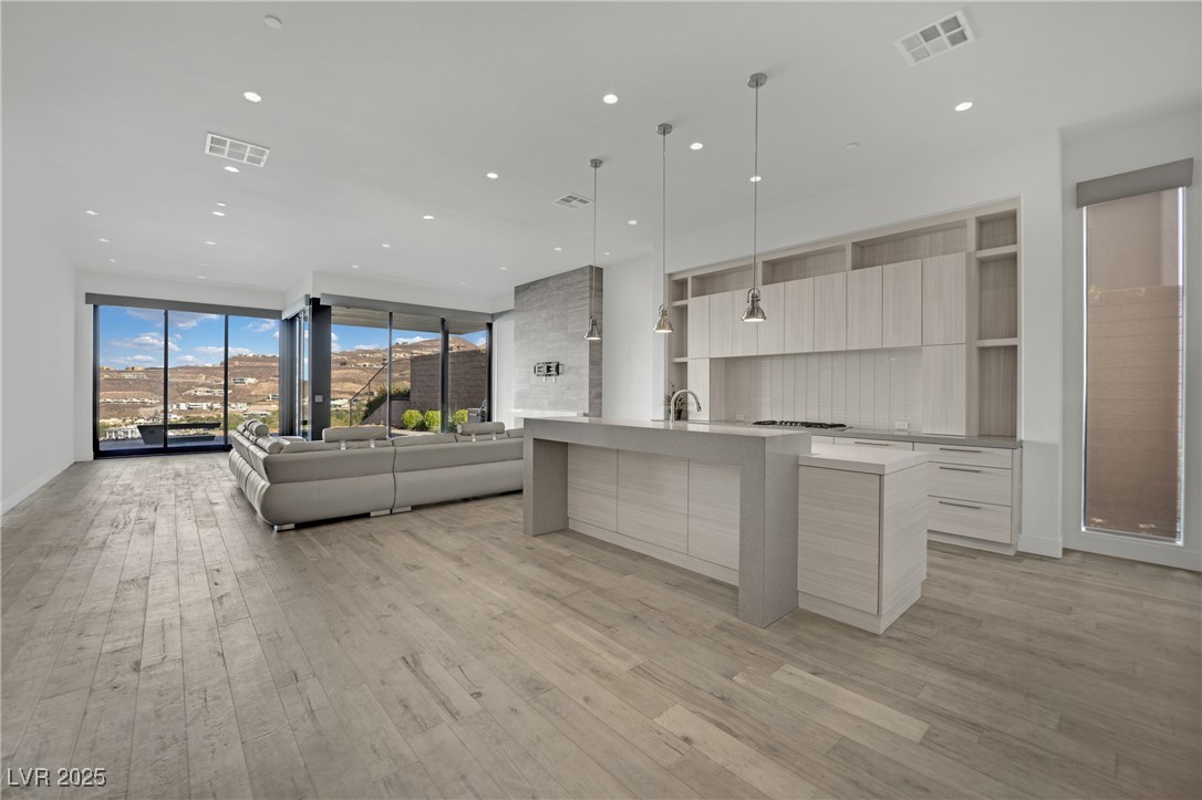 658 Falcon Summit Court Henderson, NV 89012 - Photo 7 of 99 Kitchen featuring modern cabinets, light brown cabinetry, a center island with sink, light wood finished floors, and recessed lighting