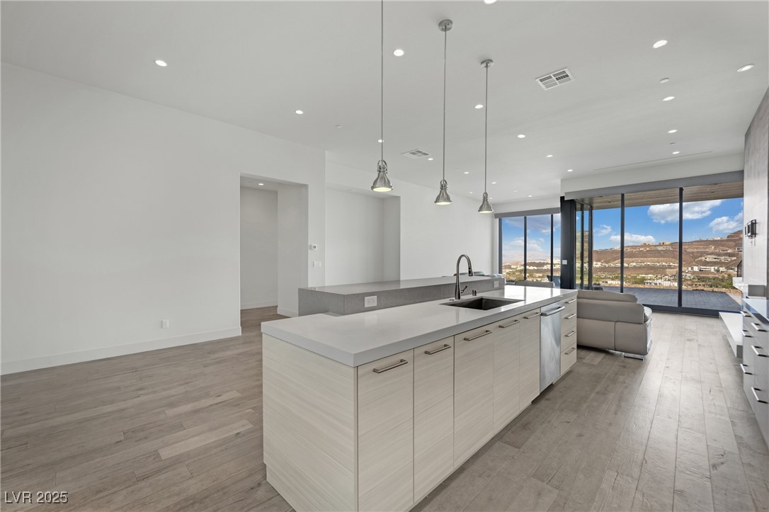 658 Falcon Summit Court Henderson, NV 89012 - Photo 99 of 99 Kitchen with open floor plan, a kitchen island with sink, hanging light fixtures, recessed lighting, and light wood-type flooring