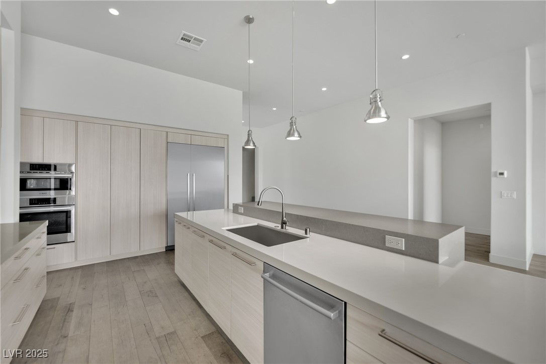 658 Falcon Summit Court Henderson, NV 89012 - Photo 9 of 99 Kitchen featuring modern cabinets, pendant lighting, light brown cabinets, and recessed lighting