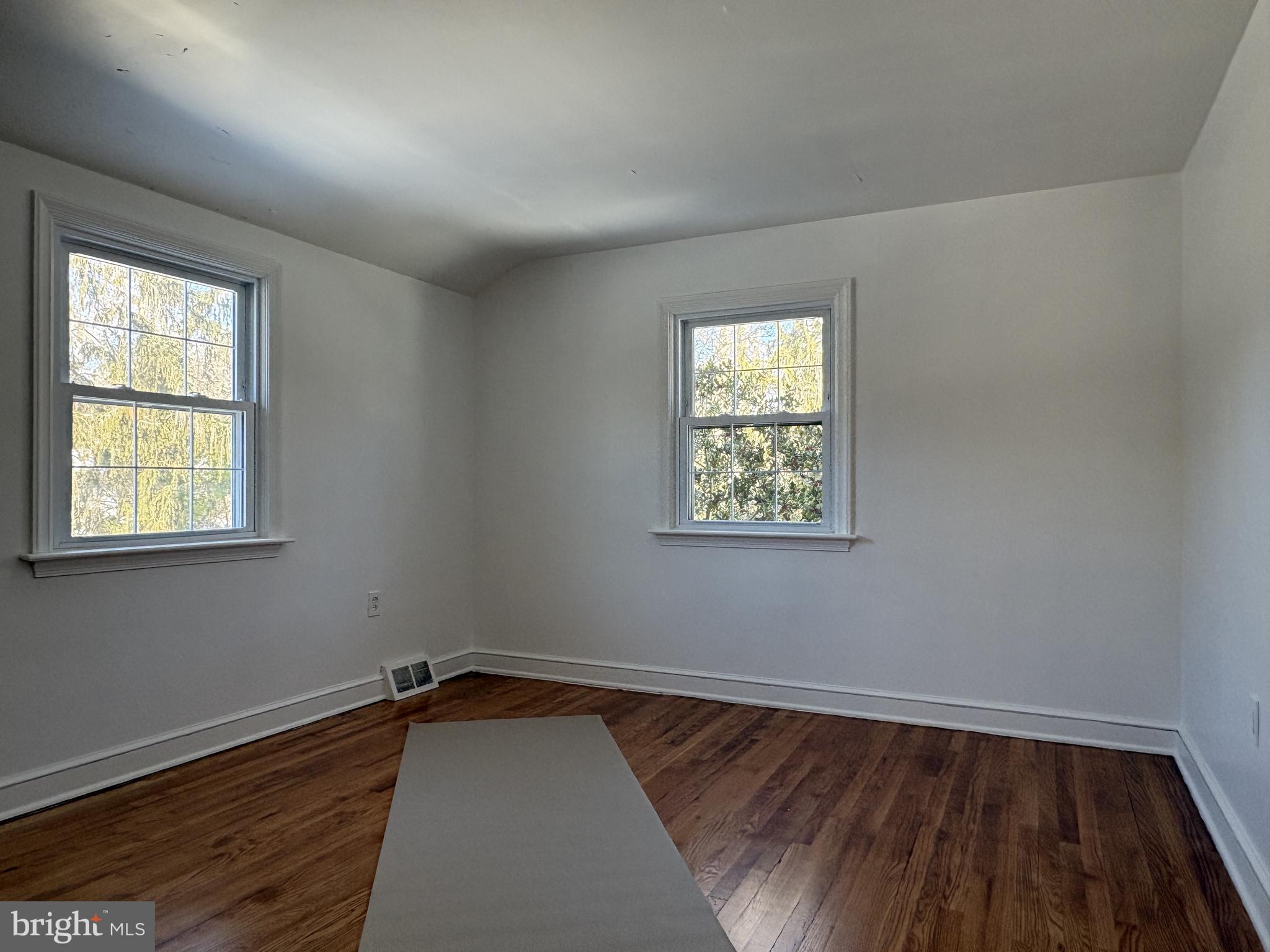 724 Brook Drive Newark, DE 19713 - Photo 36 of 37 an empty room with wooden floor and windows