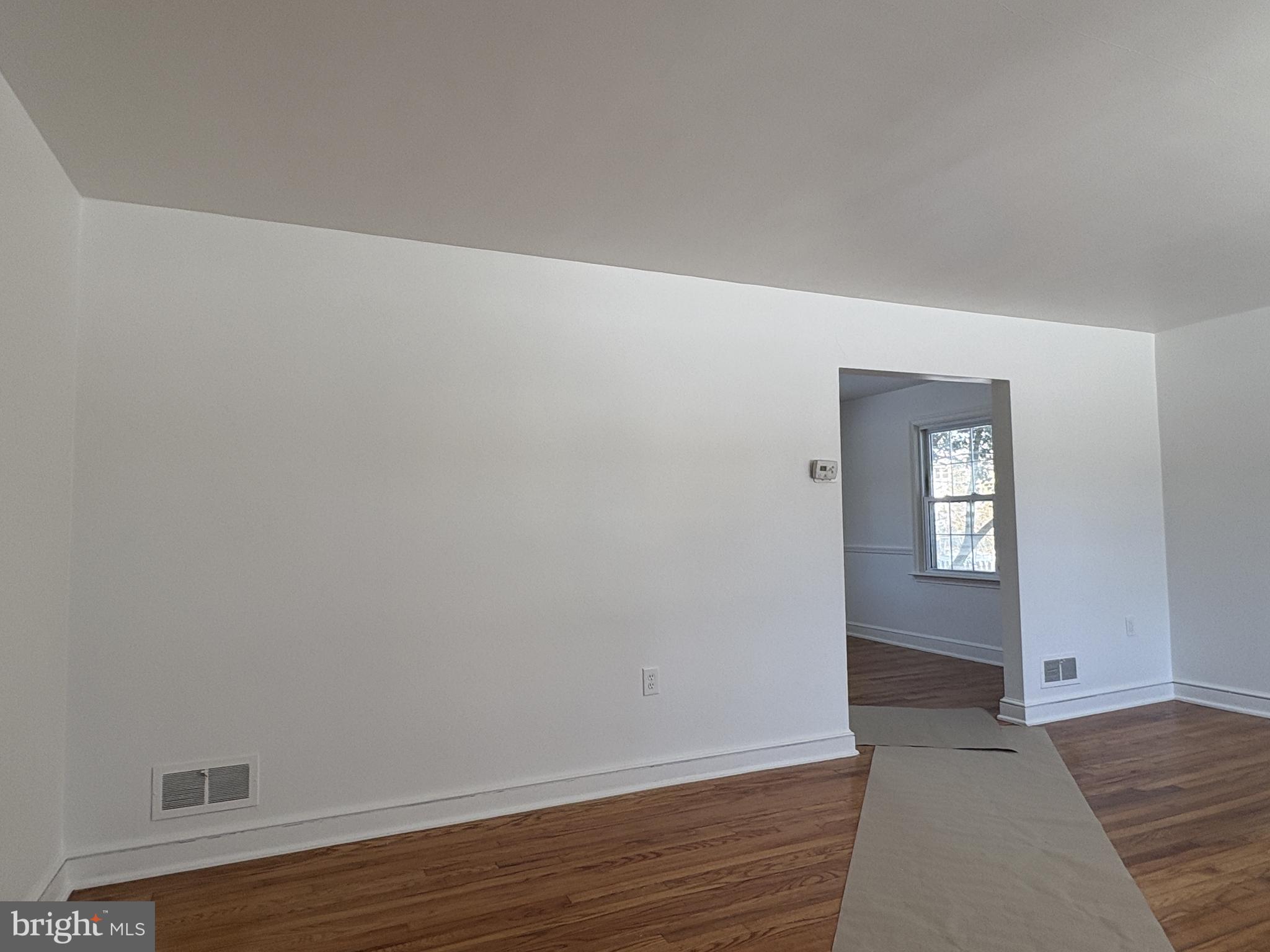 724 Brook Drive Newark, DE 19713 - Photo 5 of 37 a view of an empty room with wooden floor and a window