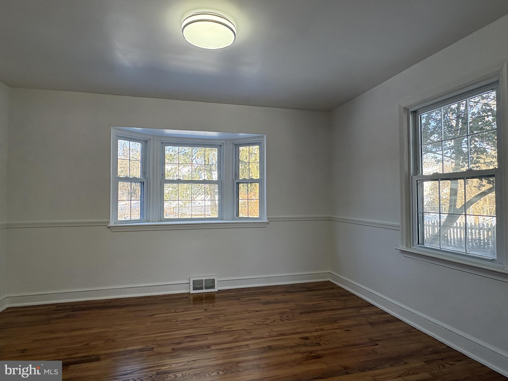 724 Brook Drive Newark, DE 19713 - Photo 7 of 37 an empty room with wooden floor and windows