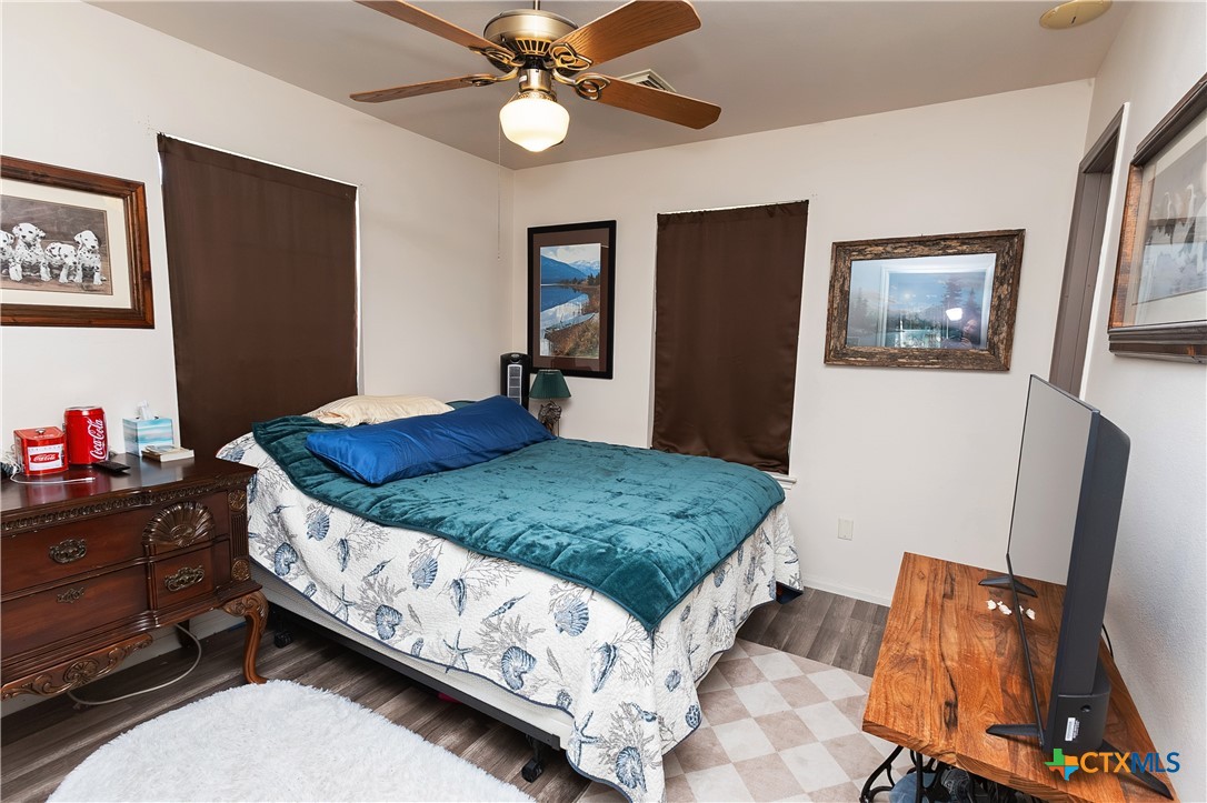 802 Bay Street Austwell, TX 77950 - Photo 17 of 27 a bedroom with a bed and a dresser in it