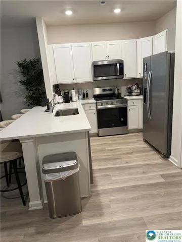 a kitchen with kitchen island a sink appliances and cabinets