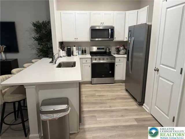 a kitchen with stainless steel appliances a stove microwave and refrigerator