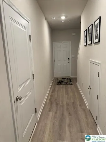 a view of a hallway with wooden floor and staircase