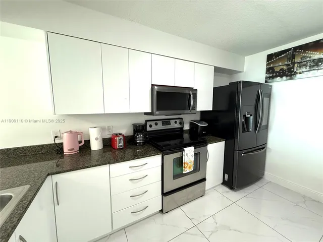 a kitchen with stainless steel appliances a refrigerator sink and microwave