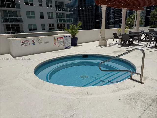 a view of swimming pool with outdoor seating and house in the background