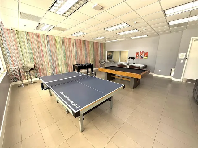 a room with pool table and a large window