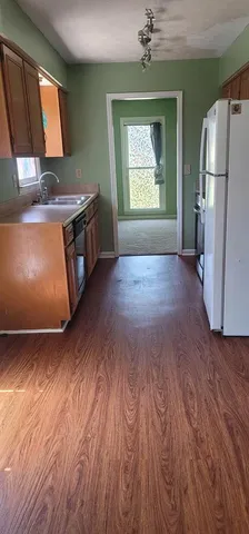 an empty room with a fireplace cabinet and wooden floor