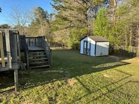 a view of a house with backyard and trees