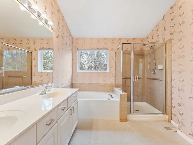 a bathroom with a tub sink shower and a mirror