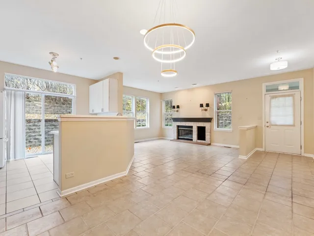an empty room with windows cabinet and a fireplace