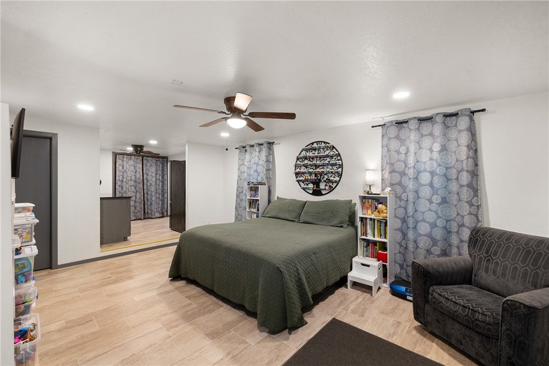 12255 County Road Centerville, TX 75833 - Photo 3 of 26 a spacious bedroom with a bed a couch and a chandelier