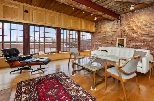 a living room with furniture a rug and a table