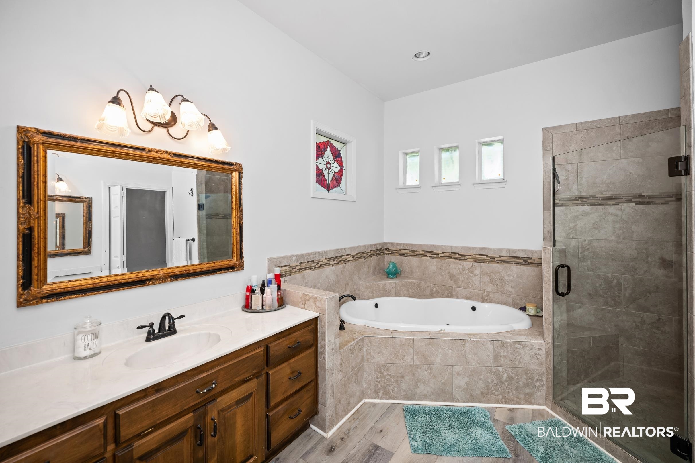 8585 Bay Harbor Road Elberta, AL 36530 - Photo 24 of 51 Full bathroom with vanity, a jetted tub, a stall shower, wood finished floors, and a chandelier