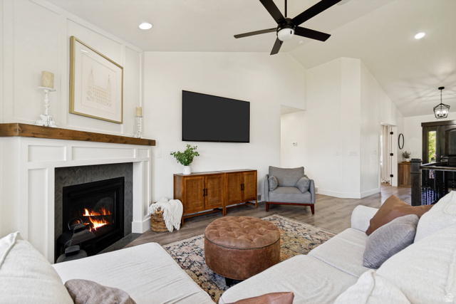 983 West 1550th Street South Springville, UT 84663 - Photo 13 of 43 Living area featuring a fireplace with a white mantel and dark tile surround, a built-in television, and vaulted ceilings.