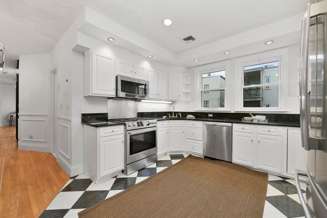 a kitchen with granite countertop a sink appliances cabinets and furniture