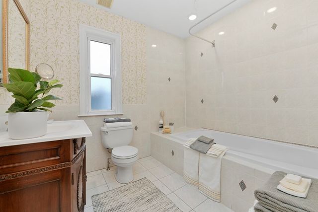a bathroom with a granite countertop sink a toilet and a mirror