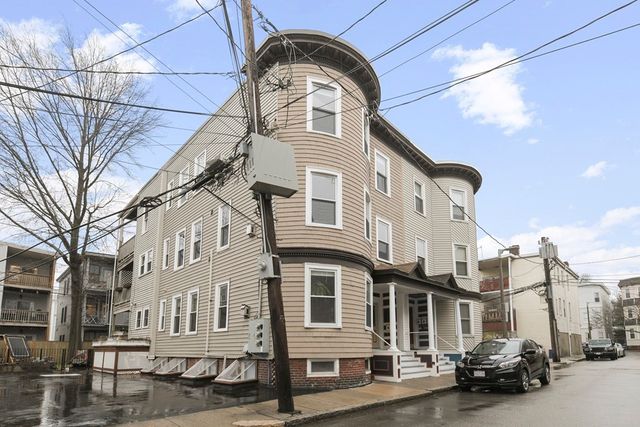 a front view of a residential apartment building with a yard