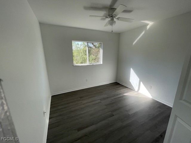 1237 Chrysler Street Lehigh Acres, FL 33974 - Photo 14 of 30 an empty room with wooden floor chandelier fan and windows