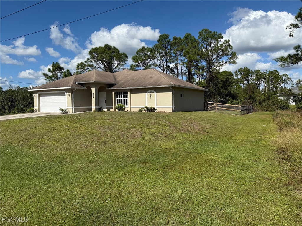 1237 Chrysler Street Lehigh Acres, FL 33974 - Photo 30 of 30 a front view of a house with a garden