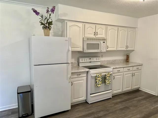 a kitchen with wooden floors and appliances