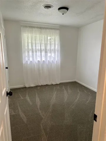 a bed sitting in a bedroom next to a window