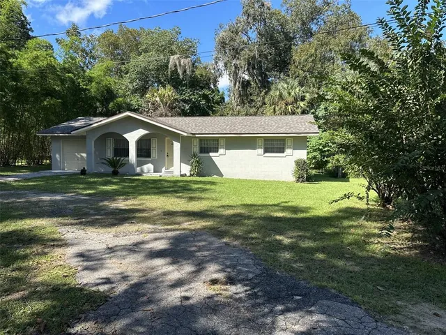 a front view of a house with yard and green space