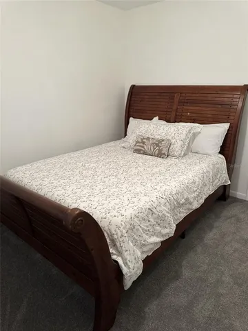 a bedroom with a bed and next to a window