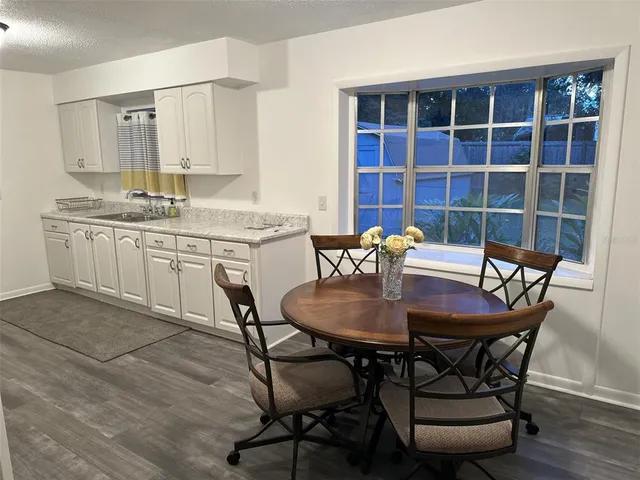 a kitchen with stainless steel appliances white cabinets and wooden floor